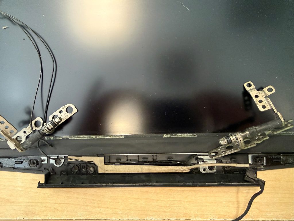 Detalle de las bisagras de pantalla metálicas desmontadas de un HP Pavilion Gaming.