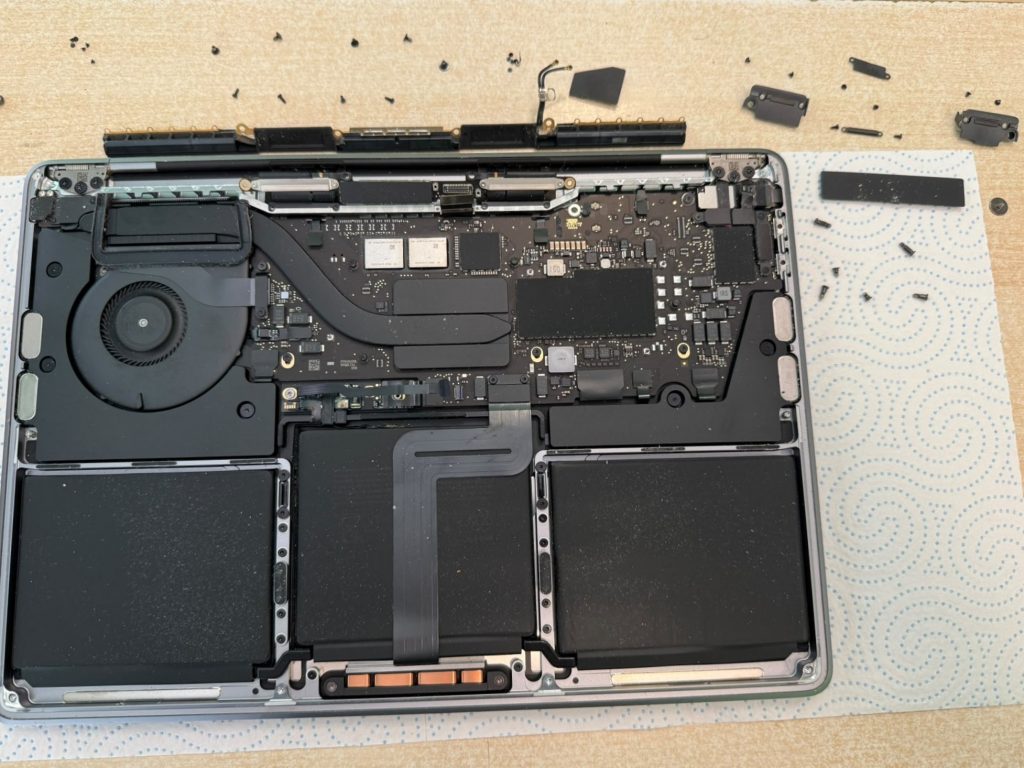 Proceso de retiro de tornillos y flexores de la pantalla en MacBook Pro A2338.