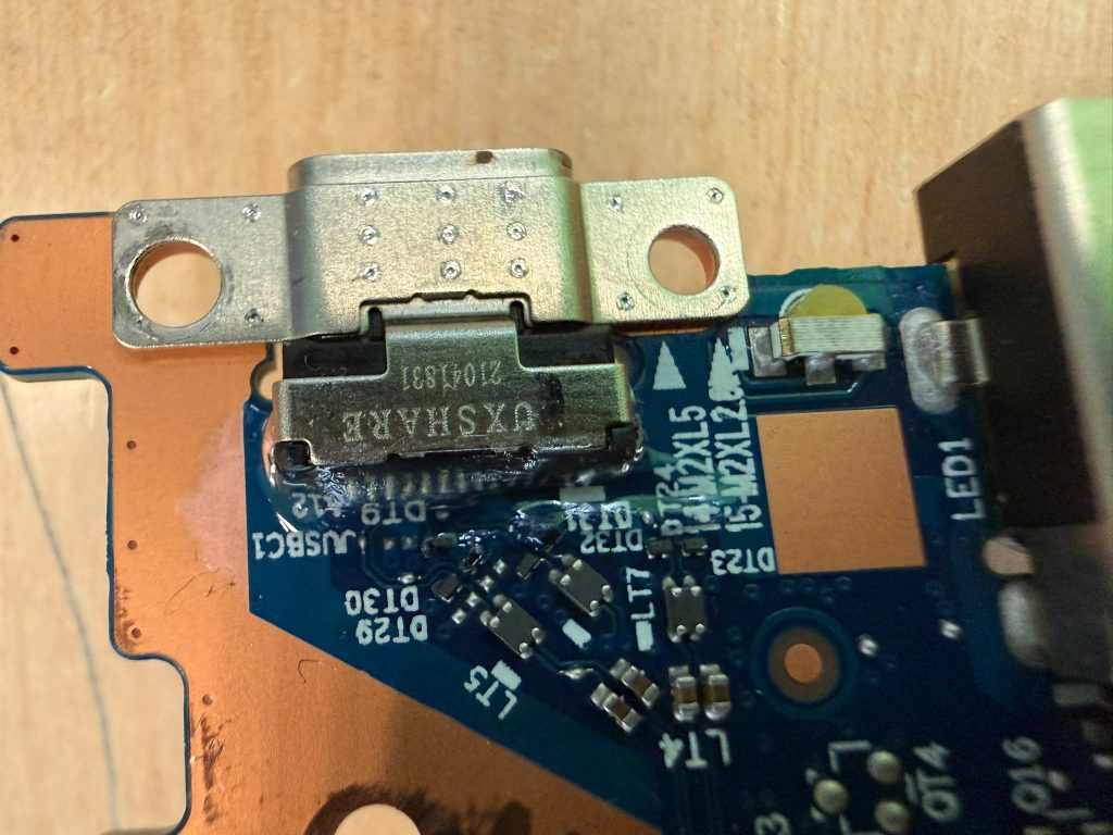 Detalle de la micro soldadura y limpieza del puerto USB-C en la placa base Lenovo.