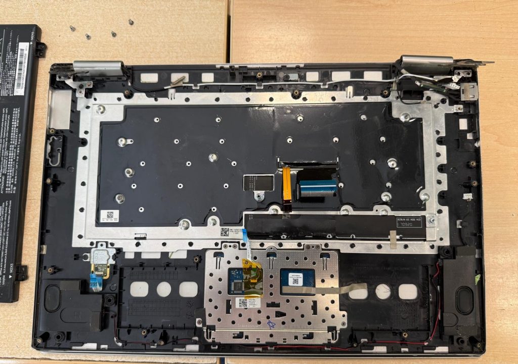 Desmontaje de la carcasa del teclado y trackpad para reparación de bisagras.