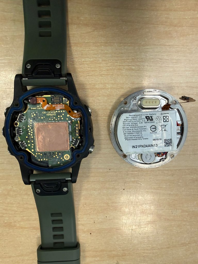 Vista interna del Garmin Fenix 5 Plus abierto, mostrando la placa base y el sellado de estanqueidad.