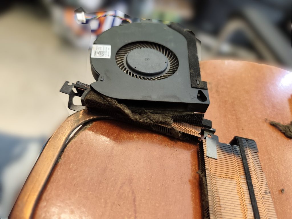 Primer plano de la acumulación de pelusa bloqueando la salida de aire en el radiador del Alienware.