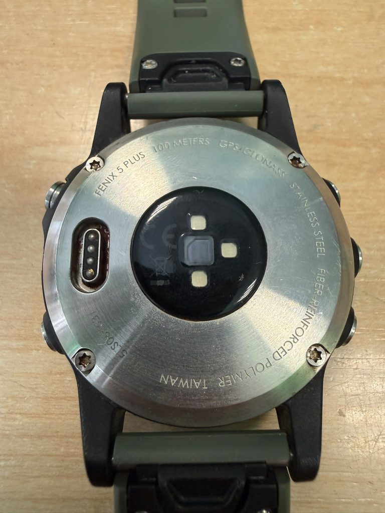 Vista trasera de acero inoxidable de un Garmin Fenix 5 Plus con sensores de frecuencia cardíaca.