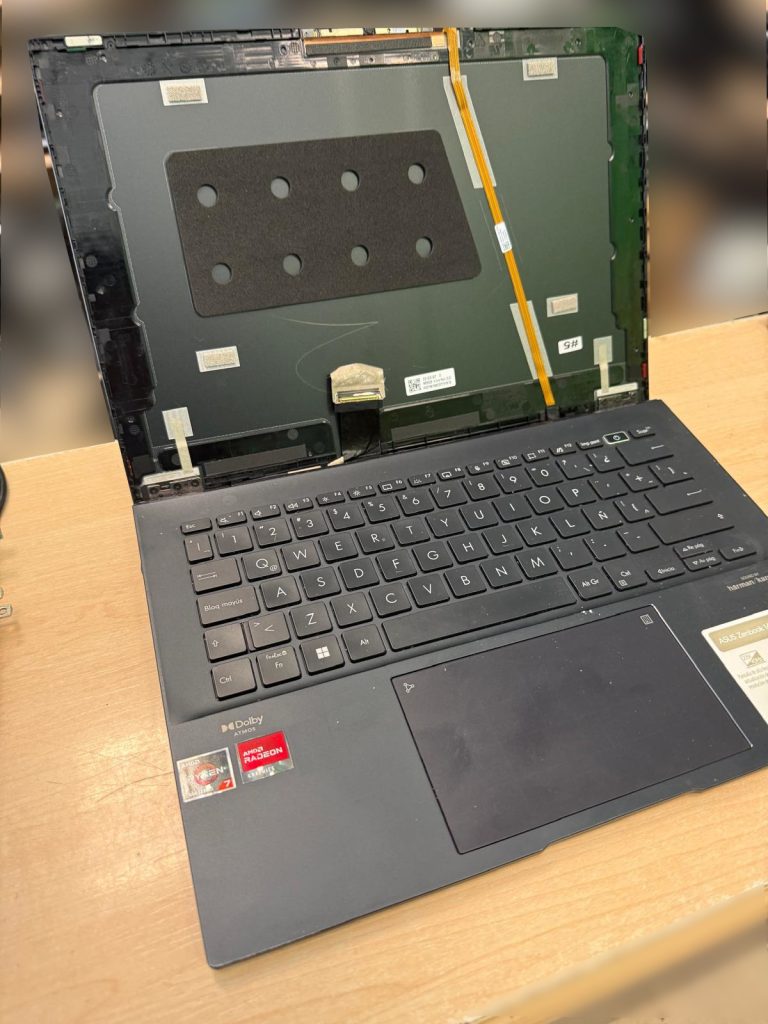 Chasis de la tapa superior del Asus Zenbook sin pantalla, mostrando el conector eDP y cables de webcam.