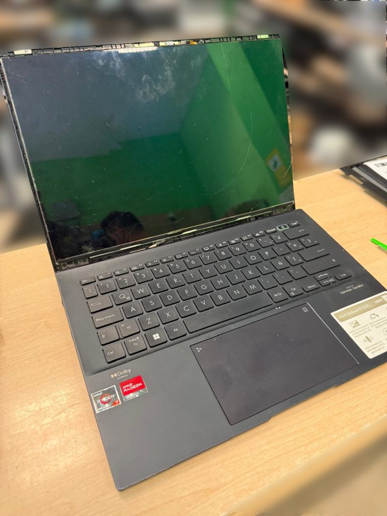 Pantalla rota con cristal estallado por impacto en la esquina inferior izquierda de un Asus Zenbook UM3402Y.