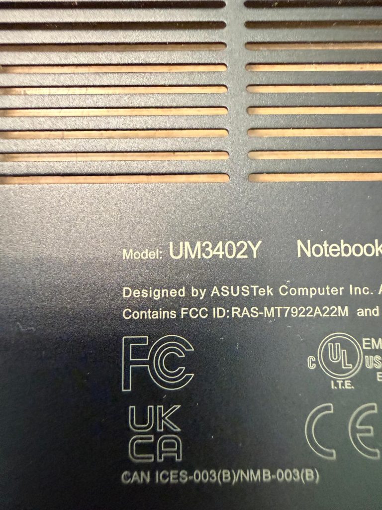 Detalle del modelo Asus UM3402Y grabado en la tapa trasera junto a las ranuras de ventilación.
