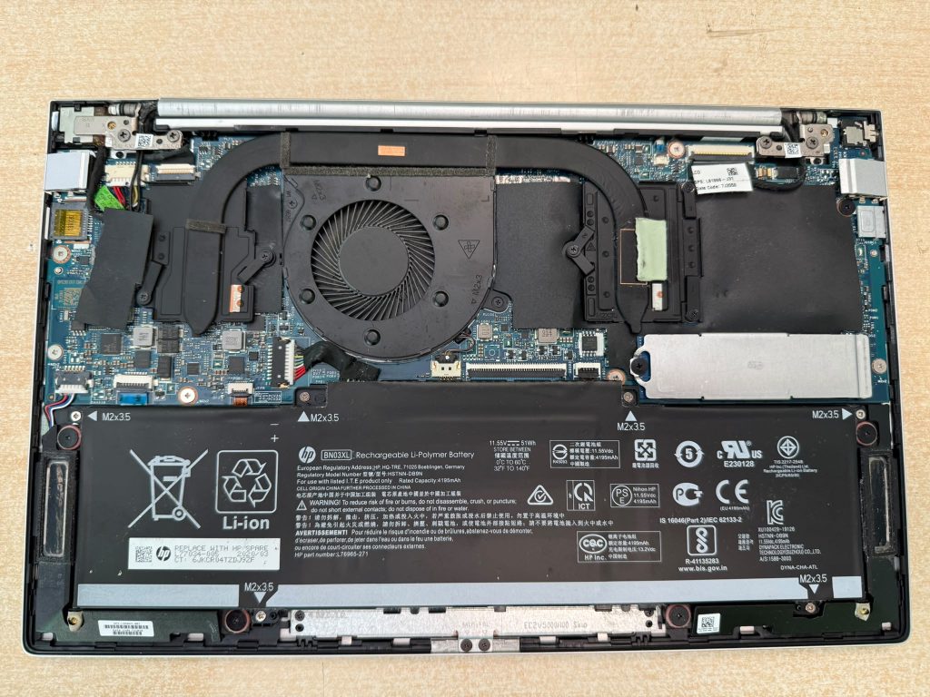 Vista interior del HP ENVY 13 abierto mostrando la batería BN03XL, ventilador y sistema de refrigeración.